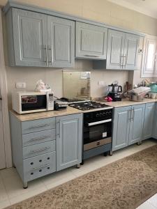 a kitchen with white cabinets and a stove top oven at Stunning Beachfront Villa on North Coast Mediterranean in Dawwār Abū Maḩrūs