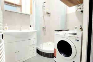 uma casa de banho com uma máquina de lavar roupa e um lavatório em CheckInVienna-One bedroom Apartment em Viena