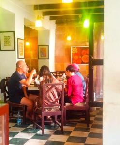 a group of people sitting at a table in a restaurant at Hotel Ananya Inn in Varanasi