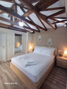 a bedroom with a large white bed with wooden ceilings at Panthea Residence in Theológos