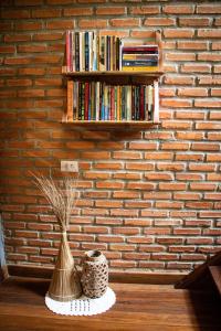 uma parede de tijolos com uma estante de livros com livros em Pousada Ksa Zen Jeri em Jericoacoara