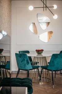 a dining room with green chairs and a mirror at Nocosfera Apartament Premium Ogrodowy II in Kalisz +32 photos
