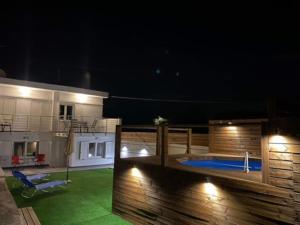 a backyard with a swimming pool at night at Maria-Irini Villa in Gournes