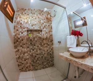 uma casa de banho com uma cabina de duche em vidro e um lavatório. em Pousada Ksa Zen Jeri em Jericoacoara