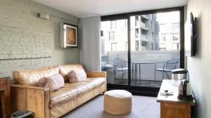 a living room with a couch and a balcony at Stylish City Clerkenwell in London