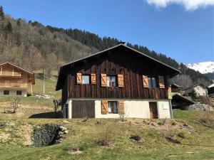 a large wooden house on a hill in a field at Chalet familial calme pour 7/8 pers, 3 chambres, proche des pistes, bien équipé et animé, 2 étoiles - FR-1-342-212 in Beaufort
