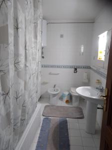 a white bathroom with a sink and a toilet at House Italia Holiday in Trabia +7 photos