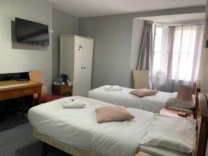 a room with two beds and a desk and a computer at Regent Hotel in Eastbourne