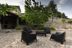 a group of black chairs and tables in a yard at Casa da Cascata in Pincães