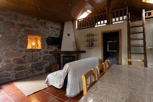 a dining room with a table and a fireplace at Casa da Cascata in Pincães