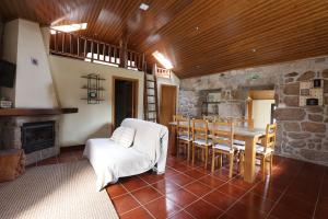 a living room with a fireplace and a table and chairs at Casa da Cascata in Pincães