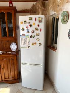 a white refrigerator in a kitchen with magnets on it at B&b Salvatore in Balestrate