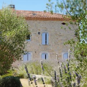 an old stone house with white windows in a garden at La Bastide in Lamillarié
