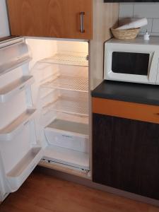 a refrigerator with its door open and a microwave at Tirano in relax in Tirano +9 photos