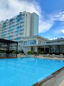 a large swimming pool in front of a building at 2BR Cozy Seaside Condo in Dumaguete in Dumaguete