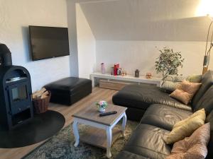 a living room with a couch and a flat screen tv at Hireu's Hus in Bötersen