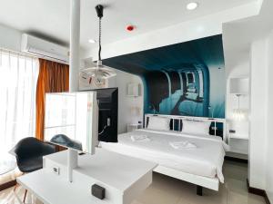 a bedroom with two beds and a blue wall at The Color Kata in Kata Beach
