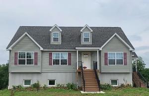 a gray house with red shutters and a porch at Giriraja Ashraya in Moundsville +5 photos