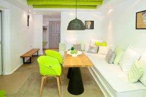 a living room with a white couch and green chairs at Golden Sun Hotel in Stelida
