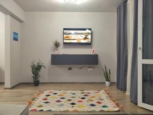 - un salon avec une télévision et un tapis dans l'établissement Altavista mountain apartment, à Samokov