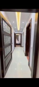 a room with a hallway with doors and a white floor at Golden in Mossadak Tower in Cairo