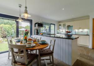 a kitchen with a wooden table with chairs and a kitchen counter at Rushmere in Reydon