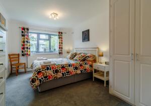 a bedroom with a bed and a desk and a window at Rushmere in Reydon