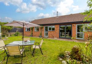 a patio with a table and chairs and an umbrella at Rushmere in Reydon