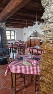 un ristorante con tavoli e sedie e un muro di pietra di MonvisoRelax a Ostana