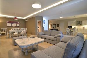 a living room with couches and a table and a kitchen at Villa Gaia in Dassia