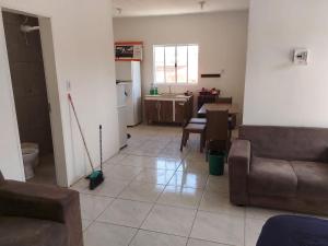 uma sala de estar com um sofá e uma cozinha em Casa laranjal em Pelotas
