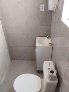 La petite salle de bains est pourvue de toilettes et d'un lavabo. dans l'établissement Casa laranjal, à Pelotas