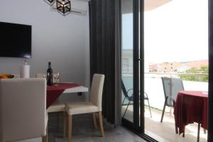 a dining room with a table and a view of a balcony at Apartments Toni in Primošten