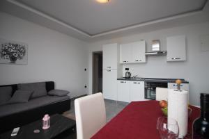 a kitchen and living room with a table and a couch at Apartments Toni in Primošten +65 photos