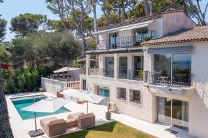 an exterior view of a house with a swimming pool at Villa Les Pins du Cap - Vue mer - Cap d'Antibes in Antibes