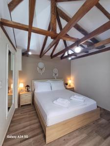 - une chambre avec un grand lit blanc et du parquet dans l'établissement Panthea Residence, à Theológos