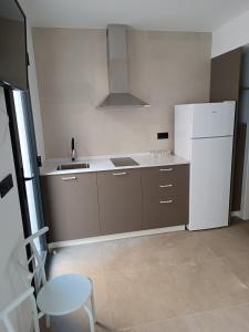 a kitchen with a refrigerator and a table and a chair at APARTAMENTOS Posada Del Mar in Los Mártires