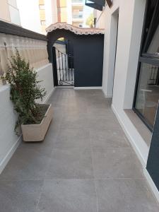 a tile walkway with a black gate and a plant at APARTAMENTOS Posada Del Mar in Los Mártires