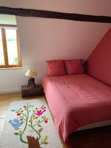- une chambre avec un lit rouge et un tapis d'arbre dans l'établissement Maison de charme en pleine nature, à Saint-Germain-des-Grois