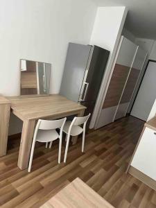 a kitchen with a wooden table and two chairs at Bratislava Centrum, Ahoj park apartments, 6floor with balcony in Koliba