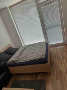 a small bed in a room with a large window at Bratislava Centrum, Ahoj park apartments, 6floor with balcony in Koliba