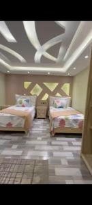 2 Betten in einem Zimmer mit einer Decke in der Unterkunft golden inn mossdek in Kairo