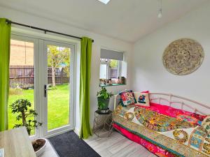 um quarto com uma cama e uma porta de vidro deslizante em Tortoise Haven Bicester- Comfortable quiet home with garden em Stratton Audley
