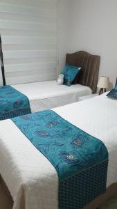 2 Betten mit blauer und weißer Bettwäsche in einem Zimmer in der Unterkunft Wohnung in Mahmutlar
