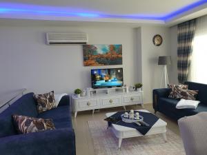 ein Wohnzimmer mit einem Sofa und einem TV in der Unterkunft Wohnung in Mahmutlar