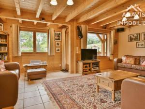 a living room with a couch and a tv at Chalet Le Grand-Bornand, 12 pièces, 20 personnes - FR-1-391-114 in Le Grand-Bornand