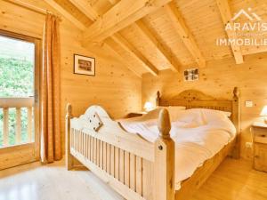 een slaapkamer met een bed in een blokhut bij Chalet Le Grand-Bornand, 12 pièces, 20 personnes - FR-1-391-114 in Le Grand-Bornand