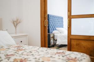 een slaapkamer met een bed, een stoel en een spiegel bij Casa Bogart in Ourense