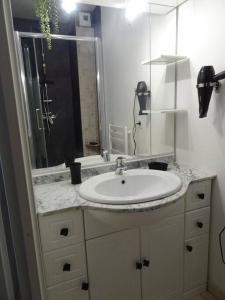 a bathroom with a white sink and a mirror at Maison 4/6 personnes de 50 m² in Les Mathes