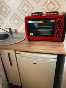 a red microwave sitting on a counter next to a sink at STUDIO GARE MONTPARNASSE in Paris